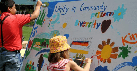 Children painting a Unity in Community mural at a Burlington event